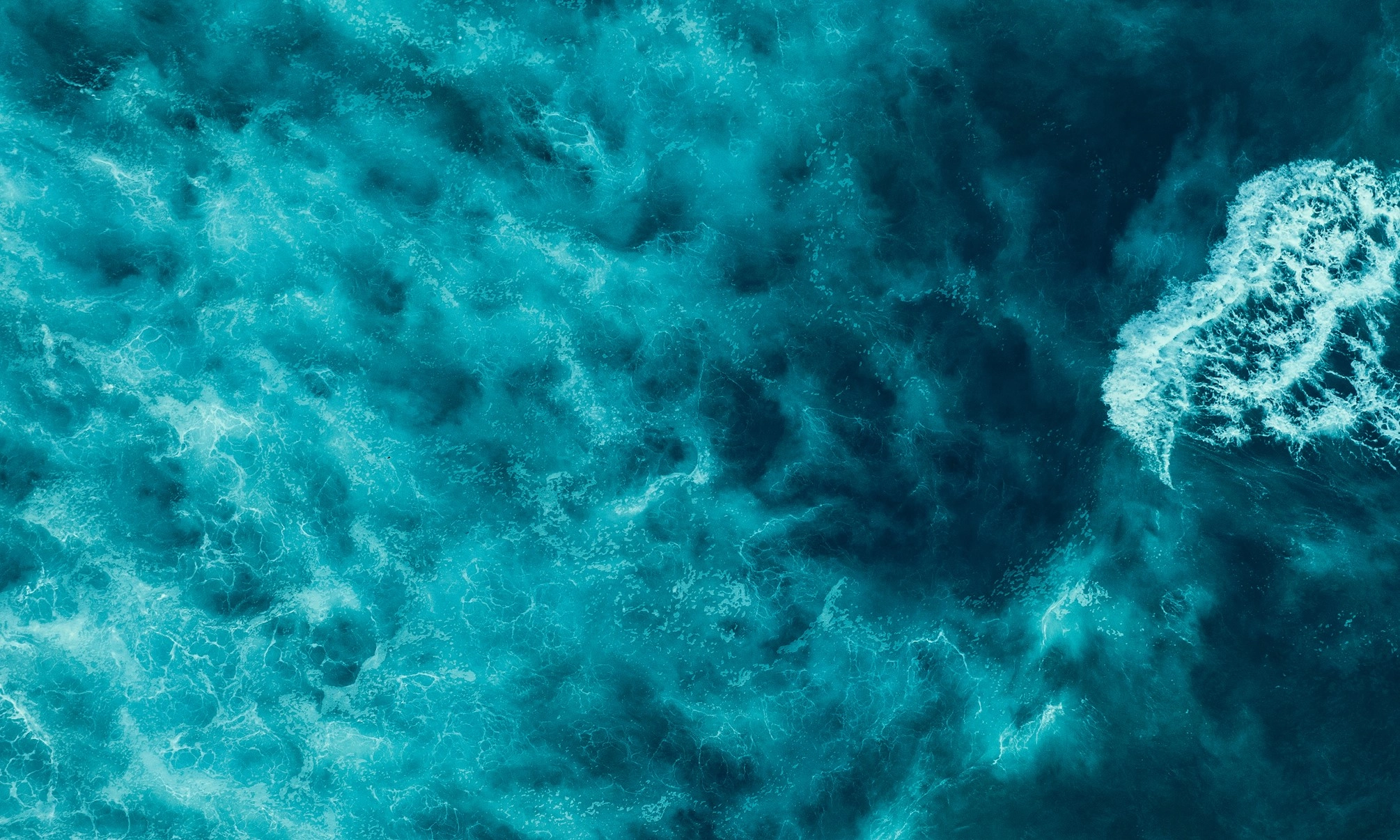 Aerial view of the ocean with waves crashing.