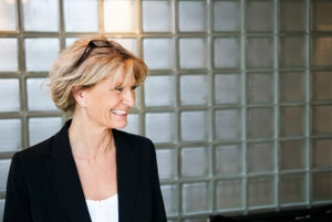 Release the talent inside of your company. A smiling business woman looking to the right.