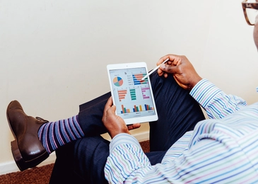 Silmälasipäinen mies tutkii myyntituloksia